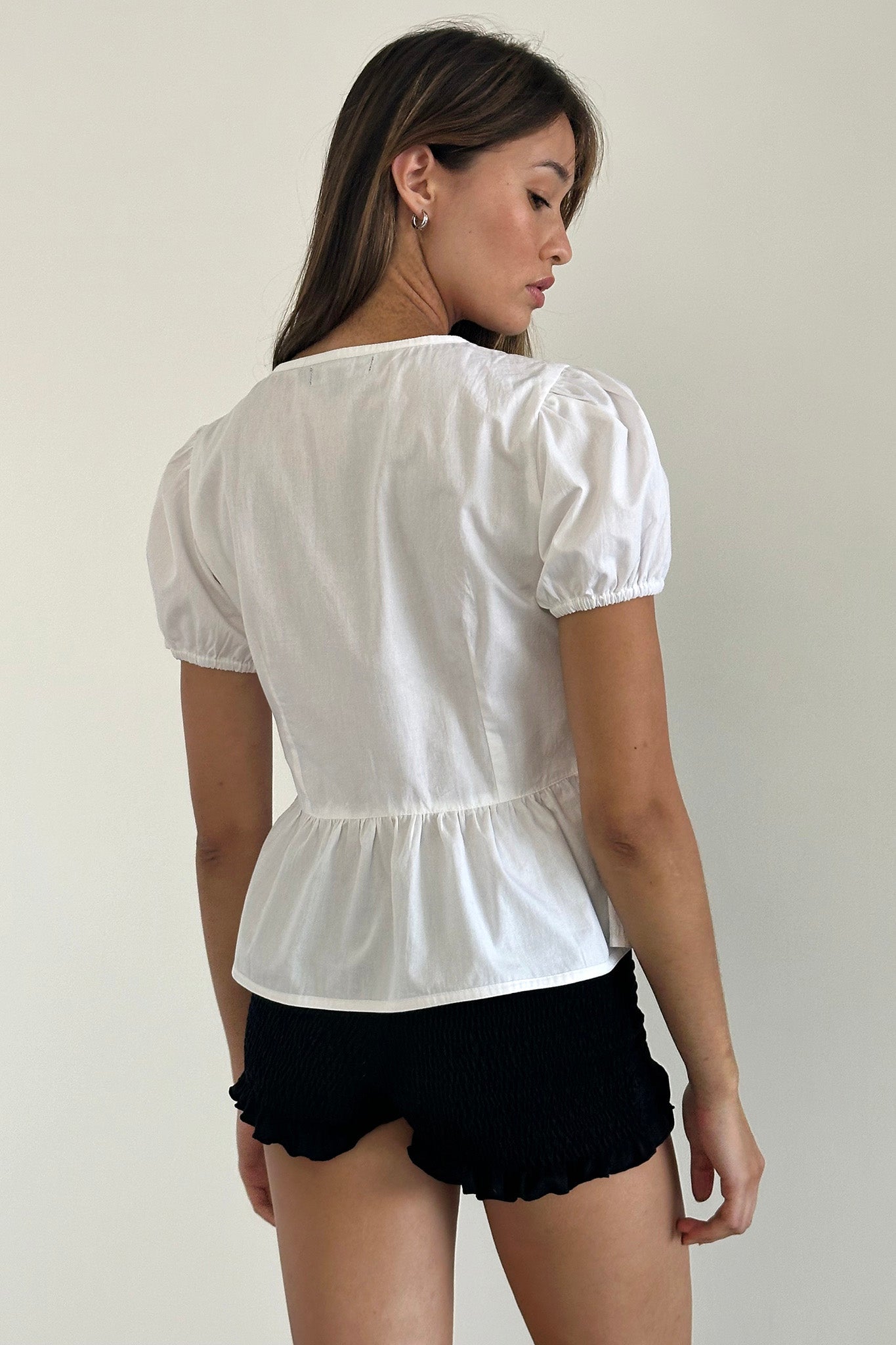 Top bianco con maniche a sbuffo e nodo sul davanti in stile scandinavo