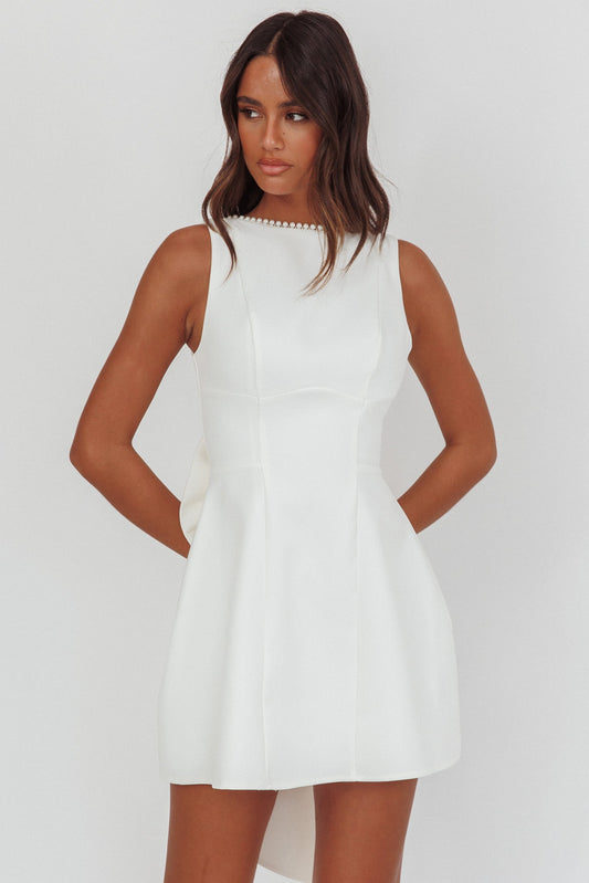 Mini abito bianco con fiocco oversize e finiture in perle opulente