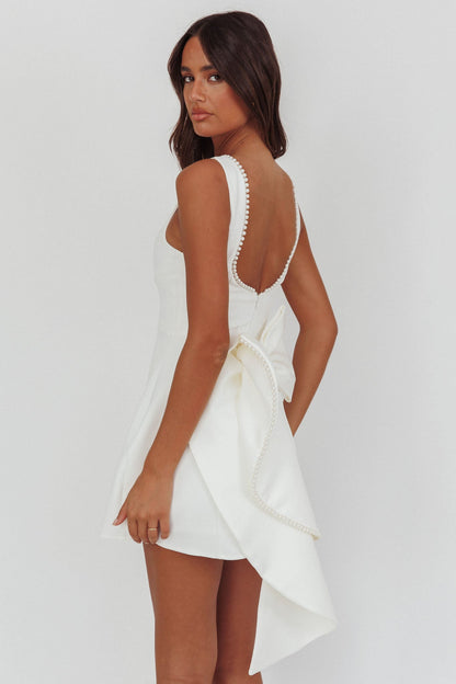 Mini abito bianco con fiocco oversize e finiture in perle opulente