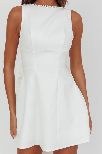 Mini abito bianco con fiocco oversize e finiture in perle opulente