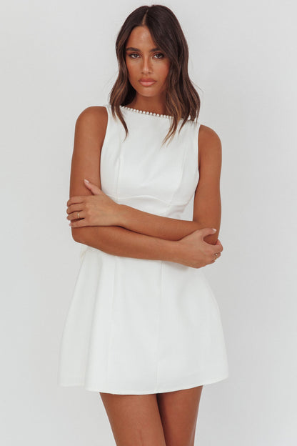 Mini abito bianco con fiocco oversize e finiture in perle opulente