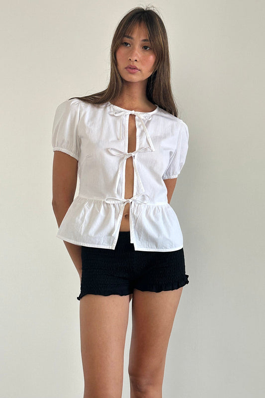 Top bianco con maniche a sbuffo e nodo sul davanti in stile scandinavo