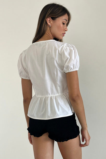 Top bianco con maniche a sbuffo e nodo sul davanti in stile scandinavo